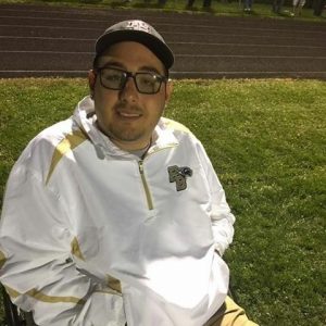 Stephen poses smiling on the football field.